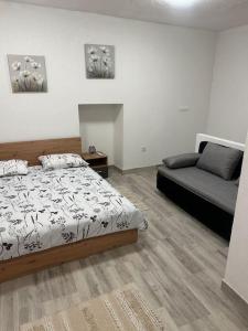 Un dormitorio con una cama y un sofá. en Apartman Kastel, en Kaštela