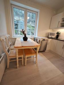 uma cozinha com uma mesa de madeira e cadeiras numa cozinha em Rekkehus Tyssedal Trolltunga em Tveit