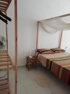 a bedroom with a bed with a canopy at Chambre espacée et lumineuse in Mbour