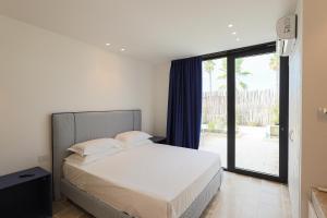 a bedroom with a bed and a large window at Valerio Resort beach club in Margherita di Savoia