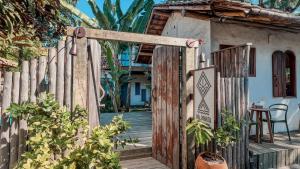 een toegang tot een huis met een houten hek bij Pousada Da Praia CARAIVA in Caraíva
