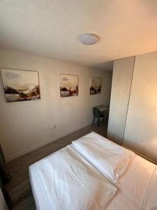 a bedroom with a white bed and a desk at Altstadt Hotel Schwanen in Waldshut-Tiengen