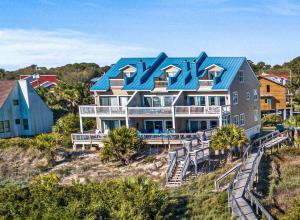 a large house with a blue roof on a beach at Ocean Queen in Tybee Island