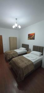 2 Betten in einem Zimmer mit Deckenventilator in der Unterkunft City Center Apartment in Shkodra