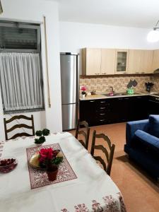 uma cozinha e sala de jantar com uma mesa com flores em City Center Apartment em Shkodër