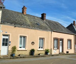 a brick building with windows and a roof at La maison du Perrin in Gréez-sur-Roc