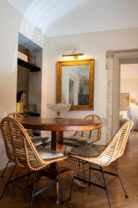 een eettafel met rieten stoelen en een spiegel bij San Giuseppe apartment con Terrazza in Siracusa