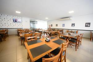 an empty restaurant with wooden tables and chairs at Colonial Flat Hotel in Itapetininga