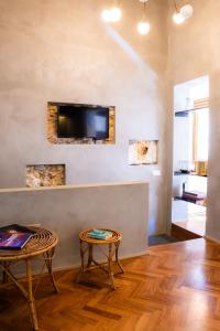 een woonkamer met twee tafels en een tv aan de muur bij San Giuseppe apartment con Terrazza in Siracusa