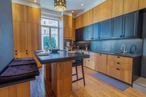 una cucina con armadi in legno e piano di lavoro nero di Elegant Bel Epoque Apartment In Center Of Menton a Mentone