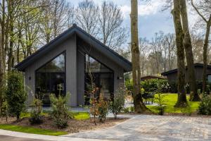 a small house in a park with trees at Vakantiepark Latour in Oirschot