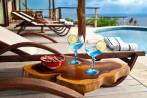 two glasses of margaritas on a wooden tray next to a pool at Tet Rouge Resort in Soufrière