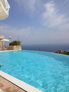 博索萊伊的住宿－2 Rooms In Luxury Residence Bordering Monaco，一个大型的游泳池,背景是大海