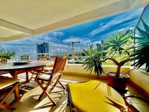 博索萊伊的住宿－2 Rooms In Luxury Residence Bordering Monaco，阳台配有桌椅和大窗户。