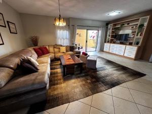 Astra Self-Catering Apartments في سواكوبموند: غرفة معيشة مع أريكة وطاولة
