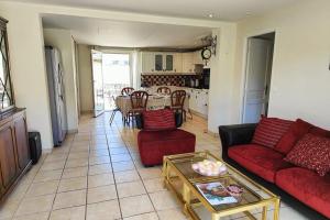 a living room with a red couch and a table at Villa à 200 m de la plage in Fréjus