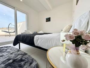 een slaapkamer met een bed en een tafel met bloemen bij Attico Magnificent [Wi-Fi/Free Parking] in Palermo