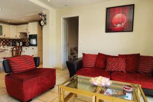 a living room with a red couch and a coffee table at Villa à 200 m de la plage in Fréjus