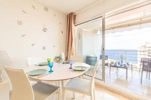 une salle à manger avec une table, des chaises et une grande fenêtre dans l'établissement Beautiful Apartment Near Monaco, à Beausoleil