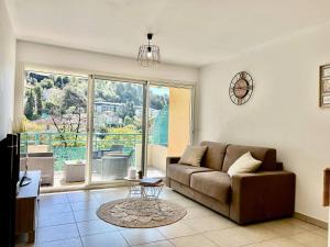 a living room with a couch and a large window at quiet studio swimming pool Roquebrune in Roquebrune-Cap-Martin