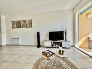 a living room with a flat screen tv and a table at quiet studio swimming pool Roquebrune in Roquebrune-Cap-Martin