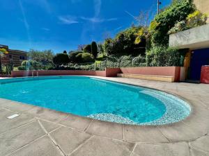 a swimming pool with blue water in a yard at Quiet Studio Swimming Pool Roquebrune in Roquebrune-Cap-Martin +19 photos