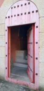 - une porte rouge dans un bâtiment en briques avec des escaliers dans l'établissement Ferienhaus für 9 Personen und 1 Kind in Lapido, Galicien Binnenland von Galicien, à Ortoño