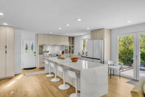 a kitchen with a large white island with white chairs at The Lakehouse in Hendersonville