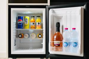 einen offenen Kühlschrank mit Getränken und Flaschen Soda in der Unterkunft Vimini Corso Cavour - City Center in Bari