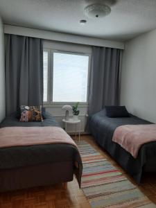 Un dormitorio con dos camas y una ventana. en Santa's Arctic Residence, en Rovaniemi
