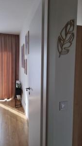 a room with a white wall and a door with a plant on it at M&M2 Brand new apartment near center with parking in Košice