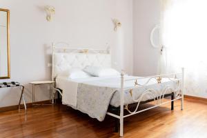 un letto bianco in una camera da letto bianca con pavimento in legno di Central View Boutique a Firenze