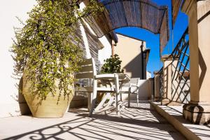 een tafel en stoel op een patio met een boog bij San Giuseppe apartment con Terrazza in Siracusa