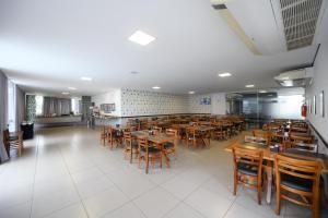a dining room with wooden tables and chairs at Colonial Flat Hotel in Itapetininga