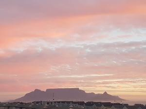 una puesta de sol con montaña de mesa en el fondo en Dolphin Ridge, en Ciudad del Cabo