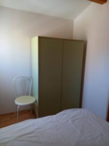 - une chambre avec un lit, une chaise et une armoire dans l'établissement HOLIDAYLAND 233 T3 MEZZANINE 7 couchages climatisé NARBONNE PLAGE, à Narbonne-Plage