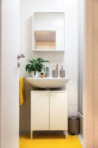 baño blanco con lavabo y planta en Kassel Rooms en Kassel