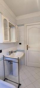 a white bathroom with a sink and a door at Victoria Apt - Historical Centre Lecce in Lecce