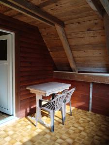 einen weißen Tisch und zwei Stühle im Dachgeschoss in der Unterkunft Wooden Treasure in Jesenice