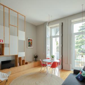 ein Wohnzimmer mit einem Tisch und Stühlen in der Unterkunft Baumhaus Serviced Living - Art & Design Apartments in Porto