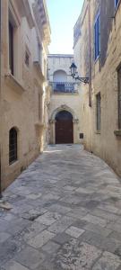 an alley with a large door in a building at Victoria Apt - Historical Centre Lecce in Lecce
