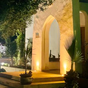 a building with an arched entryway with a palm tree at DIAR HAROUN in Djerba