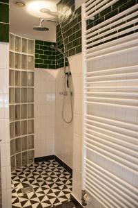 ein Bad mit einer Dusche mit schwarzen und weißen Fliesen in der Unterkunft Vakantiewoning De Pastorie in Boven-Leeuwen