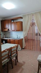 une cuisine avec des placards en bois et une table avec des chaises dans l'établissement DIMORA ANTONIANNA in VALLE D'ITRIA, à Locorotondo