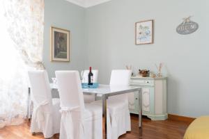 a dining room with a table and white chairs at Central View Boutique in Florence