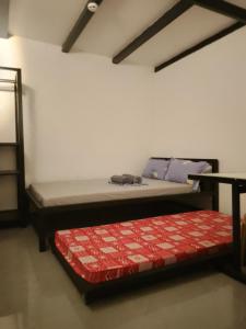 a room with two beds and a table and a bed at Shawe pension house in San Remigio