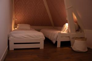 ein kleines Zimmer mit 2 Betten und einem Spiegel in der Unterkunft Vakantiewoning De Pastorie in Boven-Leeuwen