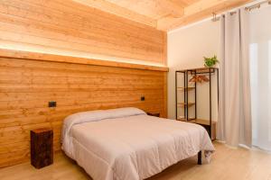 - une chambre avec des murs lambrissés et un lit dans l'établissement Cascina Cavallo, à Canale