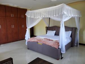 een slaapkamer met een hemelbed bij Bigodi Community Homestay in Kamwenge