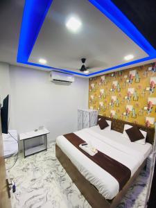 a bedroom with a large bed with a blue ceiling at Hotel 7 star in Indore